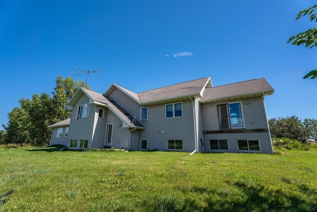 rear view of property featuring a lawn