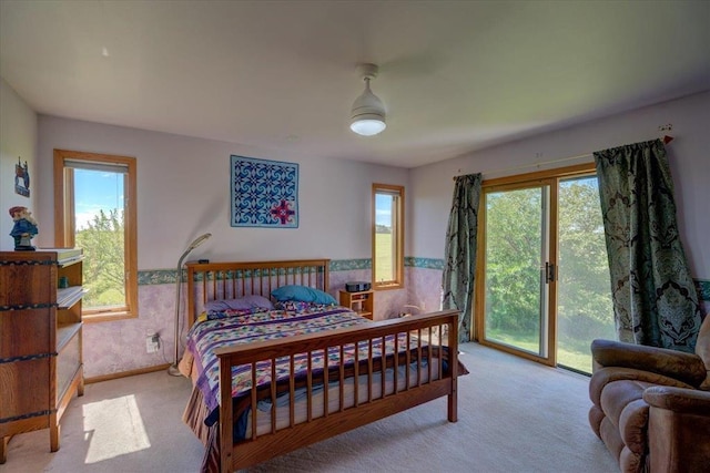 bedroom with access to exterior, ceiling fan, and light carpet