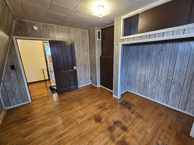 unfurnished room with hardwood / wood-style floors and wood walls