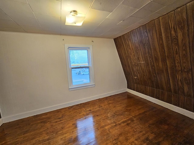 spare room with wooden walls and dark hardwood / wood-style floors