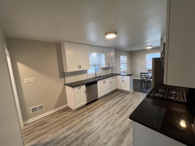 kitchen featuring white cabinets, sink, appliances with stainless steel finishes, and light hardwood / wood-style flooring