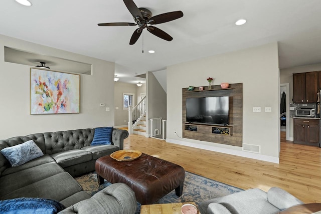 living room featuring light wood-type flooring and ceiling fan