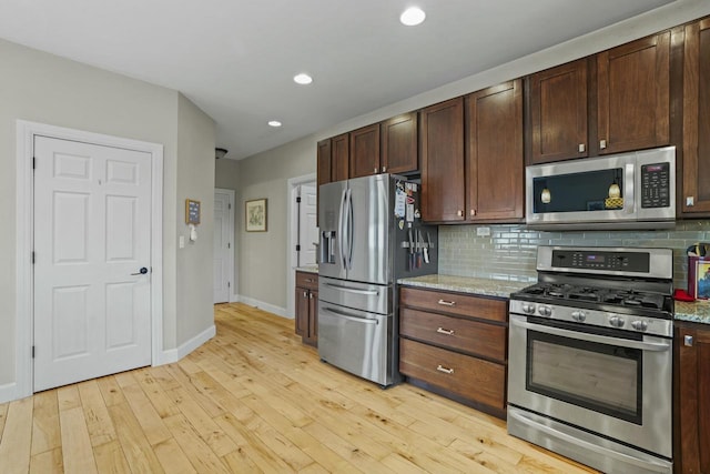 kitchen featuring light hardwood / wood-style flooring, decorative backsplash, appliances with stainless steel finishes, light stone counters, and dark brown cabinetry