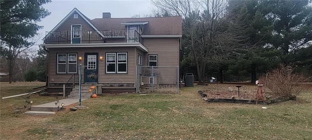 view of front facade with central air condition unit, a balcony, and a front lawn