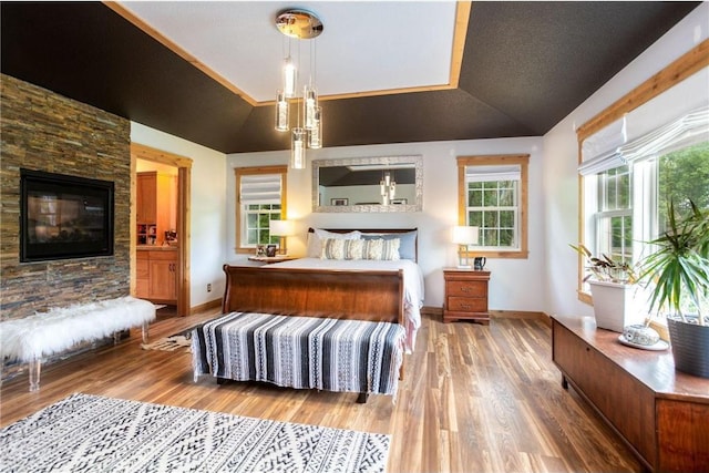 bedroom featuring hardwood / wood-style floors, vaulted ceiling, and multiple windows