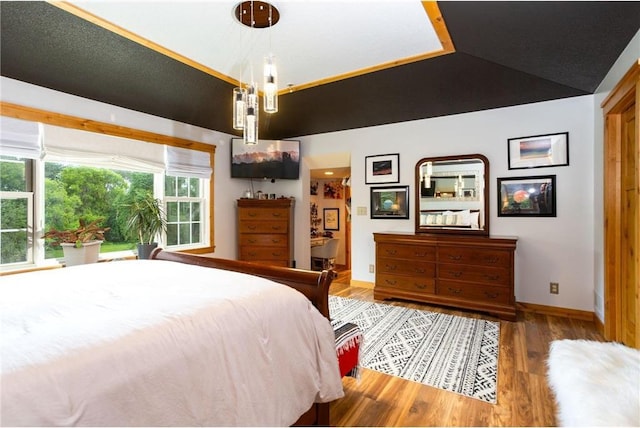 bedroom with wood-type flooring and lofted ceiling