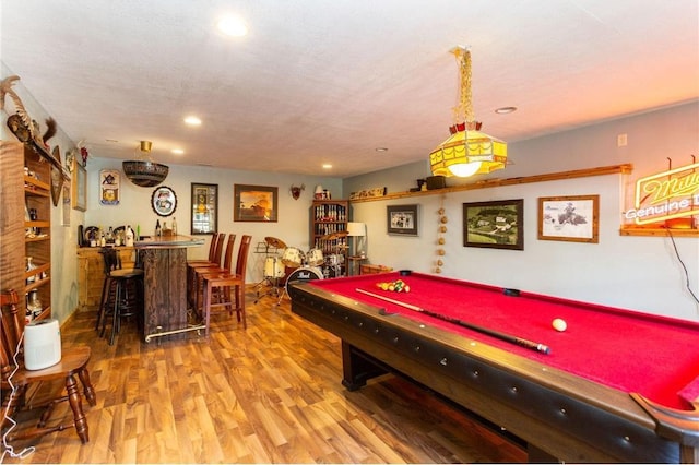 rec room featuring hardwood / wood-style floors, a textured ceiling, billiards, and indoor bar