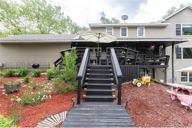 rear view of house featuring a wooden deck