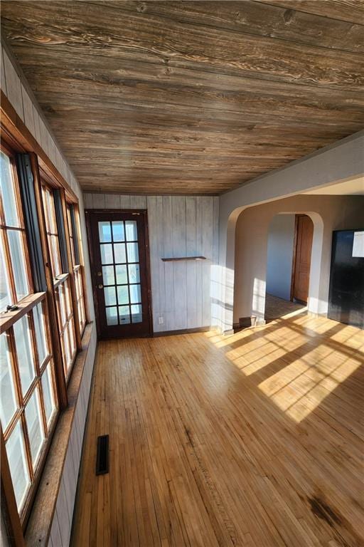 interior space featuring hardwood / wood-style flooring, wood walls, and wood ceiling