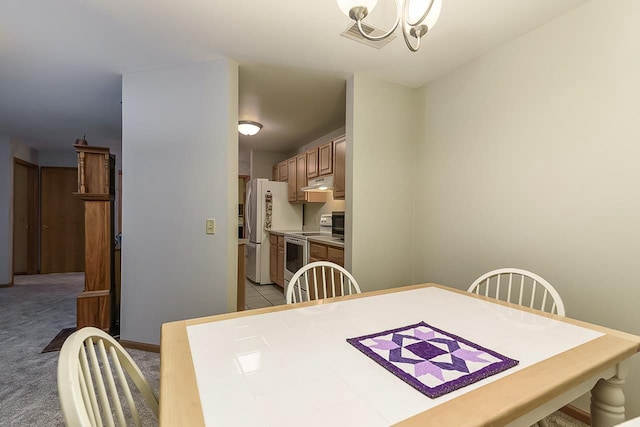 dining area with a chandelier and light colored carpet