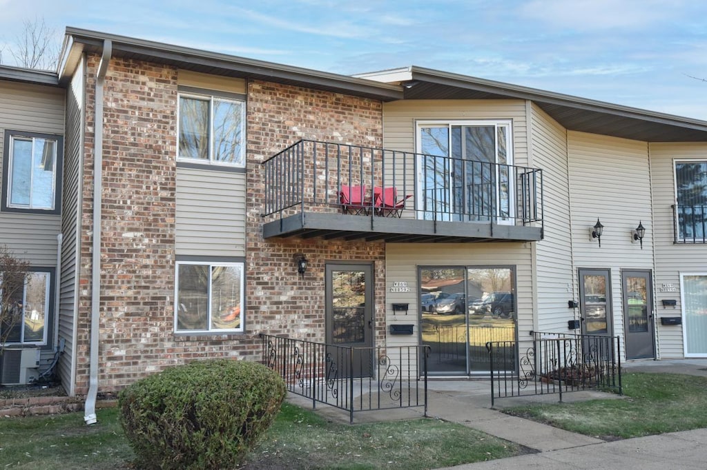 view of front of house with a balcony and central AC unit