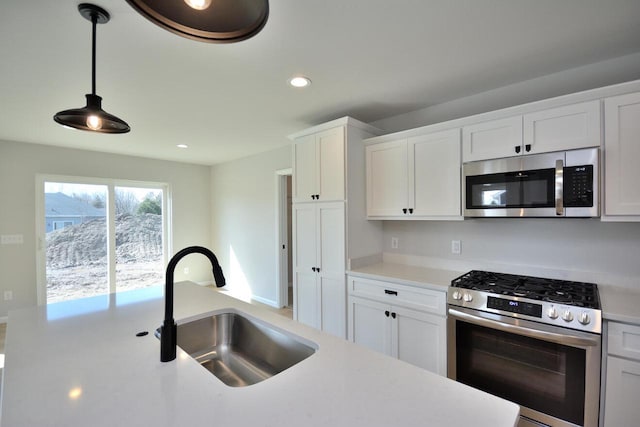 929 5 Mile Rd, Racine, WI 53402 - kitchen featuring appliances with stainless steel finishes, light countertops, recessed lighting, white cabinets, and decorative light fixtures