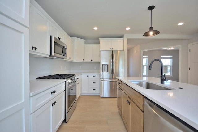 929 5 Mile Rd, Racine, WI 53402 - kitchen with appliances with stainless steel finishes, light wood-style floors, light countertops, decorative light fixtures, and recessed lighting