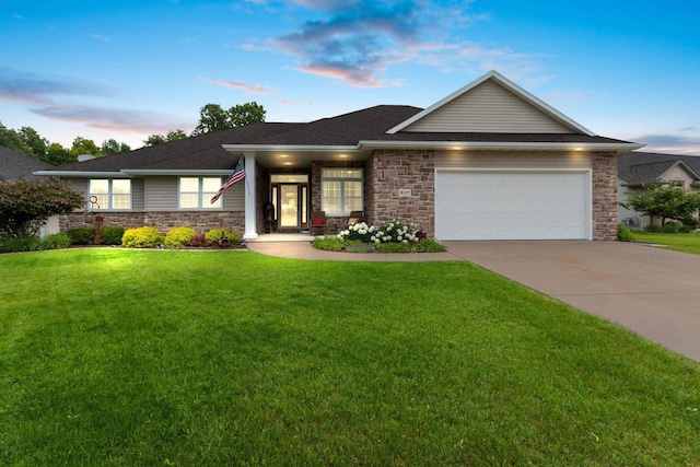 217 Hidden Ridges Way, Combined Locks, WI 54113 - view of front facade featuring an attached garage, a front lawn, concrete driveway, and stone siding