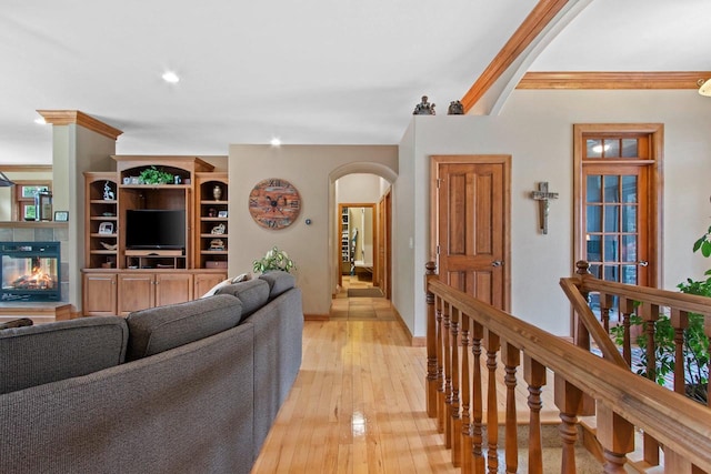 217 Hidden Ridges Way, Combined Locks, WI 54113 - living room featuring arched walkways, light wood-style floors, a fireplace, ornamental molding, and baseboards