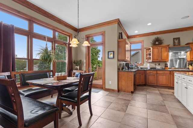 tiled dining space with sink, crown molding, and a chandelier