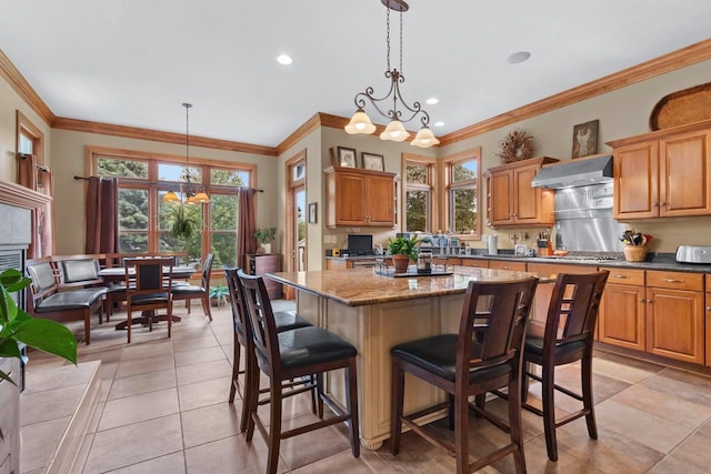 217 Hidden Ridges Way, Combined Locks, WI 54113 - kitchen featuring a chandelier, crown molding, wall chimney exhaust hood, a breakfast bar area, and a kitchen island