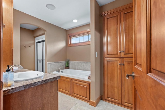 bathroom with tile patterned floors, a bathtub, and vanity