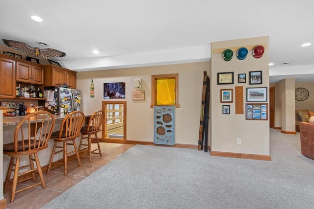 217 Hidden Ridges Way, Combined Locks, WI 54113 - kitchen featuring brown cabinets, a kitchen breakfast bar, recessed lighting, baseboards, and light carpet