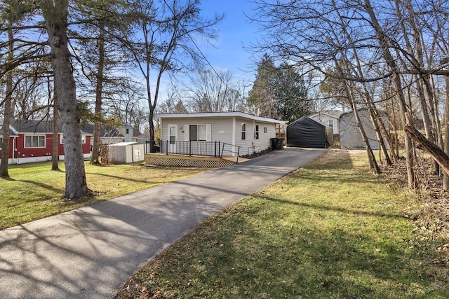 view of front of house featuring a front yard and a storage shed