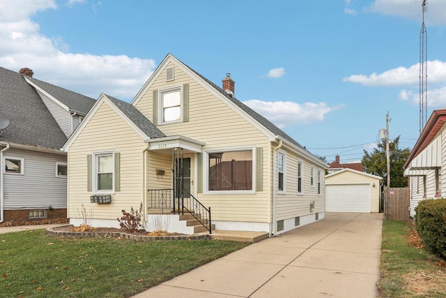 bungalow with an outbuilding, a garage, and a front lawn