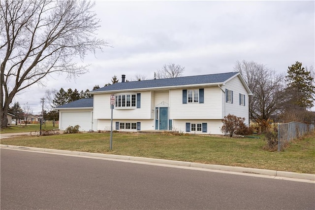 raised ranch with a front yard and a garage