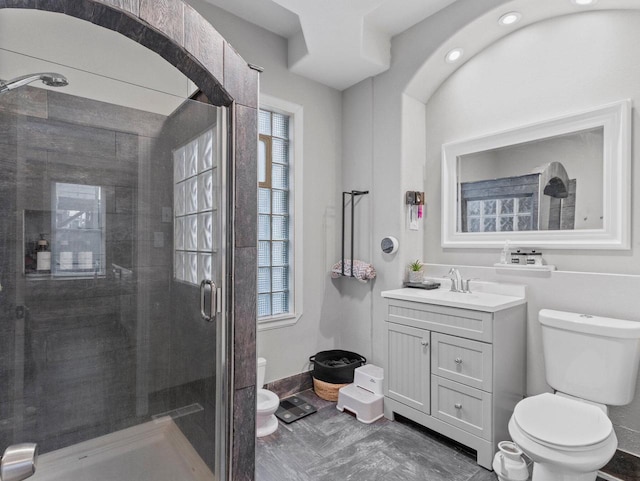 bathroom featuring walk in shower, vanity, and toilet