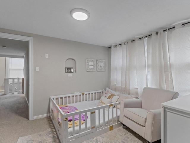 carpeted bedroom featuring a crib