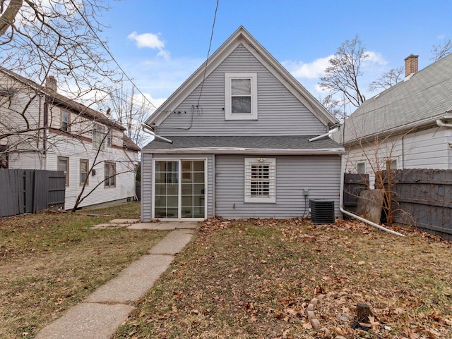 back of house featuring central AC and a yard