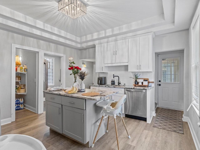 kitchen featuring dishwasher, light wood-type flooring, white cabinets, and a kitchen island