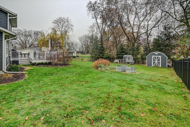 view of yard featuring a wooden deck and a shed