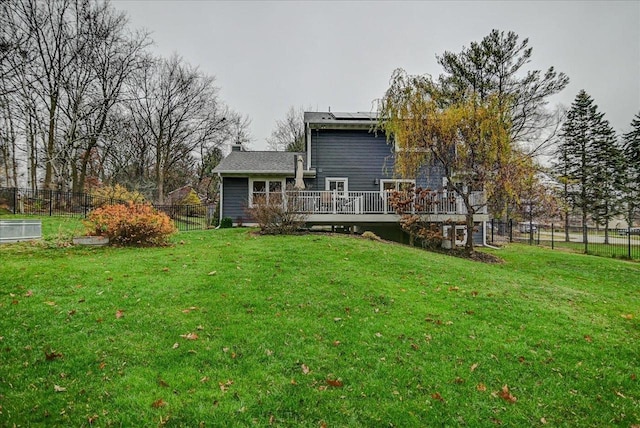 back of house with a lawn and a deck