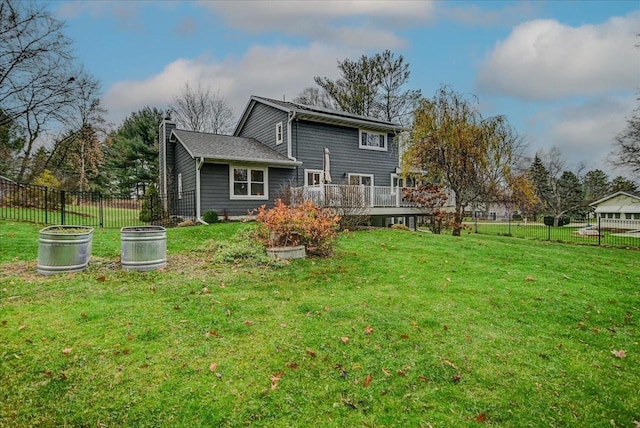 back of house featuring a lawn and a deck