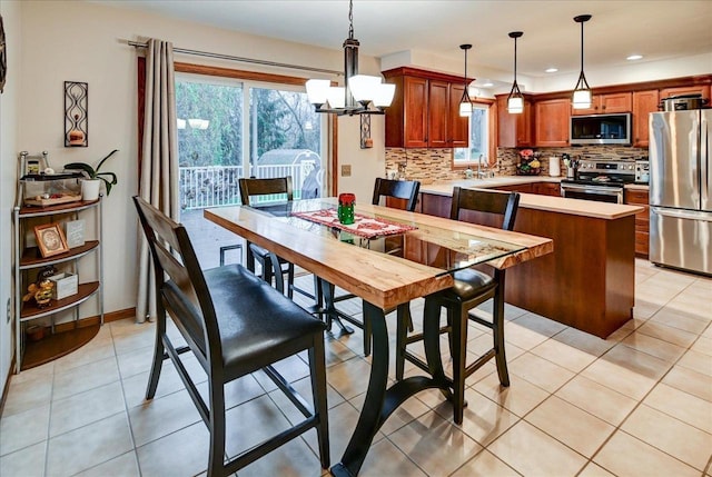 dining space with light tile patterned floors, sink, and an inviting chandelier