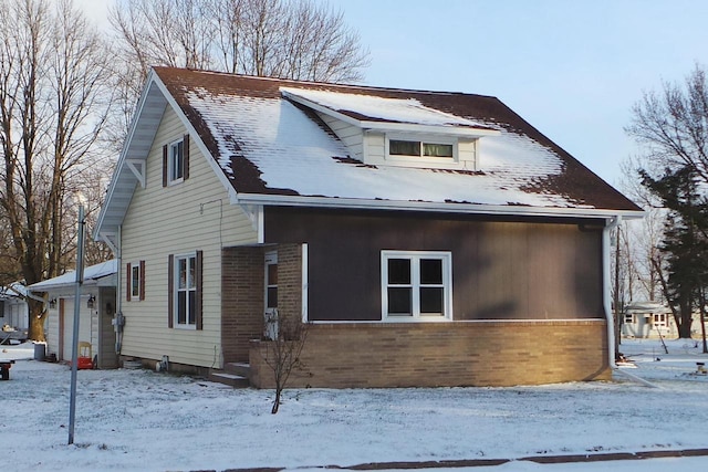 snow covered property with a garage