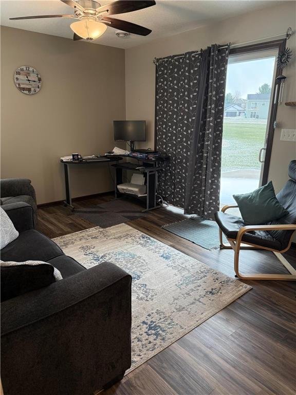 living room with ceiling fan and dark wood-type flooring