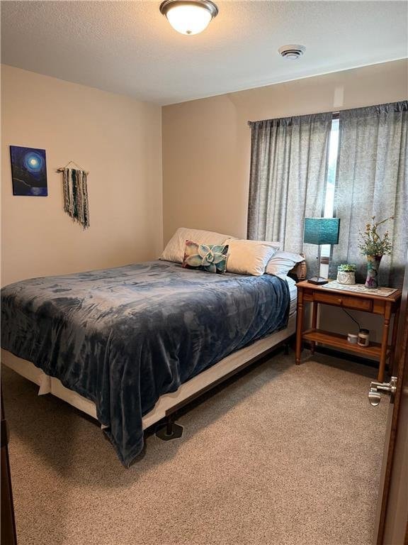 bedroom with a textured ceiling and carpet floors