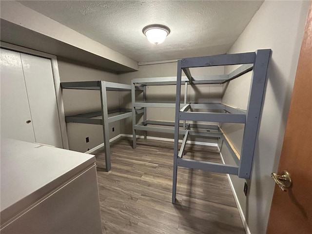 bedroom with a textured ceiling, dark hardwood / wood-style floors, and a closet