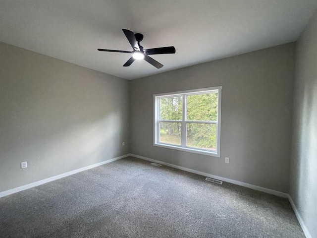 empty room with visible vents, a ceiling fan, carpet, and baseboards