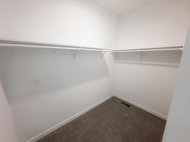 spacious closet with visible vents and dark carpet