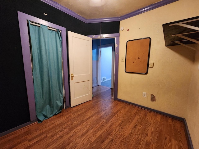 unfurnished bedroom with crown molding and hardwood / wood-style floors