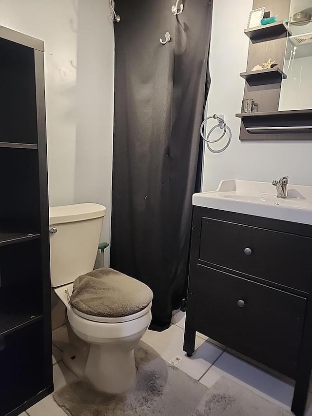 bathroom with tile patterned flooring, vanity, and toilet