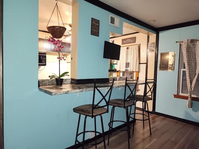 bar with hardwood / wood-style floors