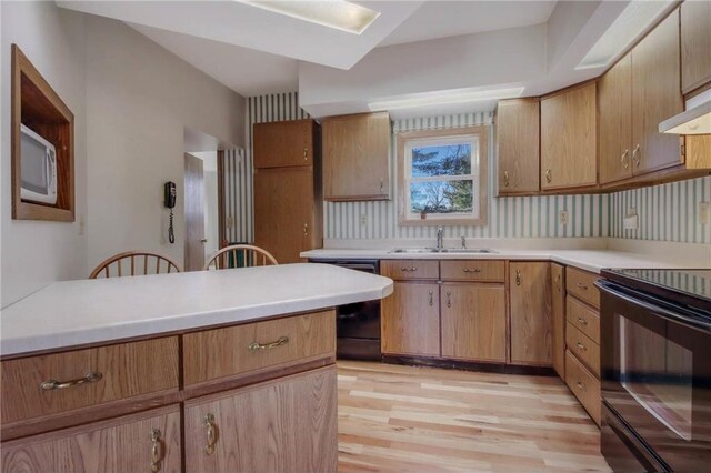 kitchen featuring tasteful backsplash, sink, black appliances, and light wood-type flooring