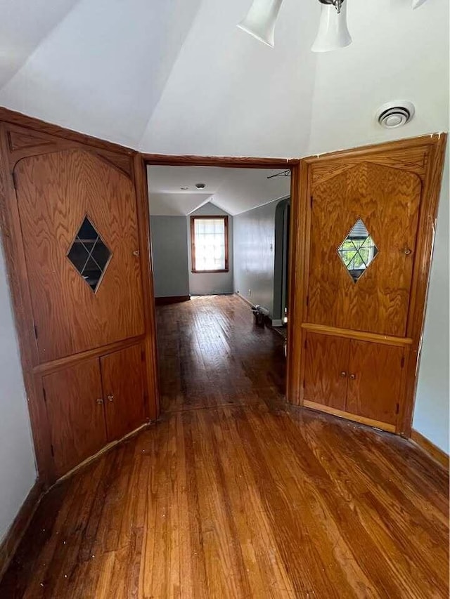 interior space featuring dark wood-type flooring and lofted ceiling