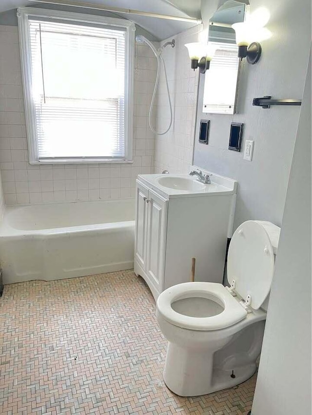 full bathroom with vanity, tiled shower / bath combo, and toilet