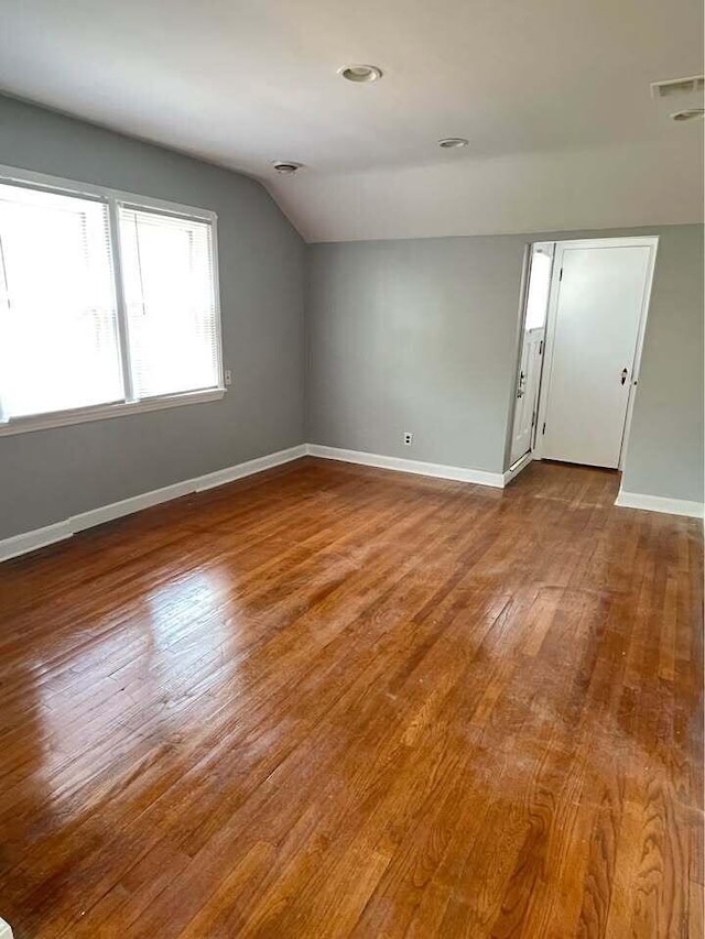 unfurnished room with vaulted ceiling and hardwood / wood-style flooring