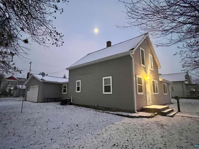 back of house featuring central AC unit, a garage, and an outdoor structure