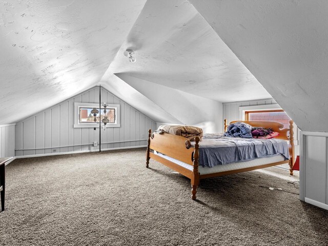 bedroom featuring carpet, a textured ceiling, and vaulted ceiling