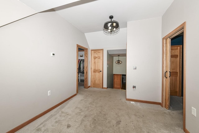 hallway featuring light colored carpet and lofted ceiling